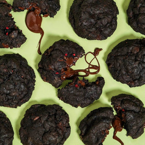 Vegan Raspberry Dark Choc New York Cookie with melted dark chocolate and raspberry pieces on green background by Crumbs & Doilies